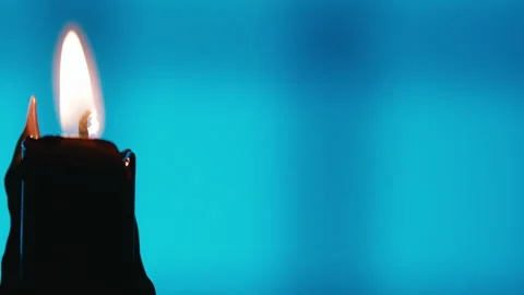 Single Black Candle Flame on Blue Background with copy space Stock Footage 317614121