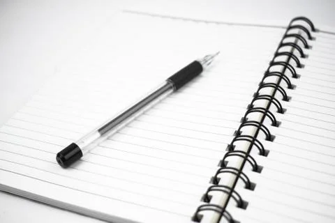 Single black colored pen placed on top of a simple open white paper diary Stock Photos