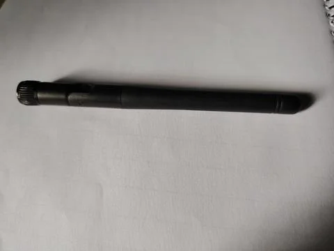 A single black plastic wireless antenna with a textured connector end is pl.. Fotos Stock
