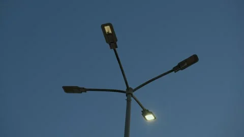 Single blinking street light against deep blue dawn sky creating mysterious Vídeos de archivo 346243946