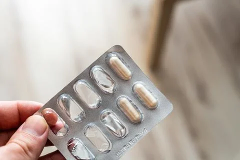 Single blister pack of capsules held in hand, showcasing dietary supplements in Stock Photos