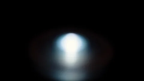 A single blue led starts out of focus and then racks to in focus. against black. 스톡 동영상 85619568