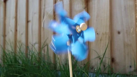 Single blue pinwheel or windmill spinning fast outdoors in sunlight Stock Footage
