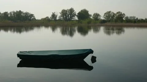 Single boat anchored in the middle of a small lake 库存影片 130956361