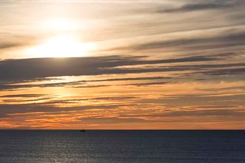 Single Boat on Ocean at Sunset Stock Photos