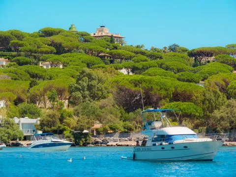 Single boats with multiple villas in the background in Saint-Tropez. Stock Photos