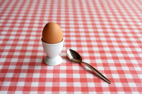 Single boiled egg with spoon ready to eat on a table Stock Photos