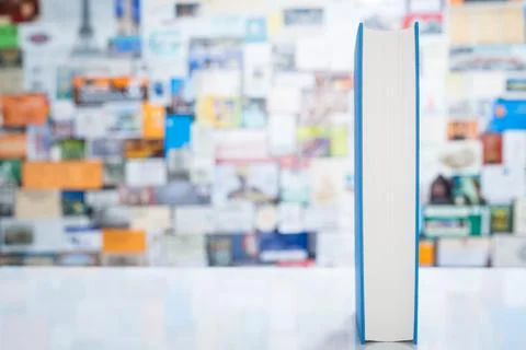 Single book standing on table in front of colorful background Stock Photos