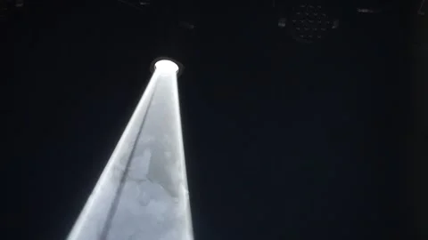 Single bright white stage spotlight beam shining through smoke Stock Footage 346358491