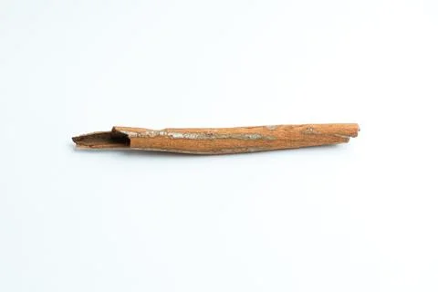 Single brown cinnamon stick spice isolated on a pure white background Stock Photos