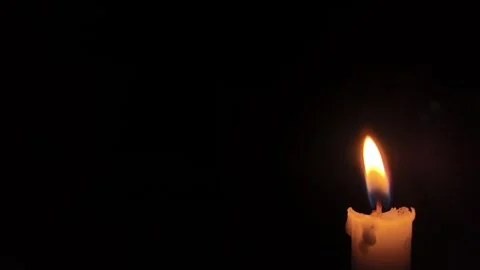 Single burning candle flame glowing in the dark background Stock Footage 347734497