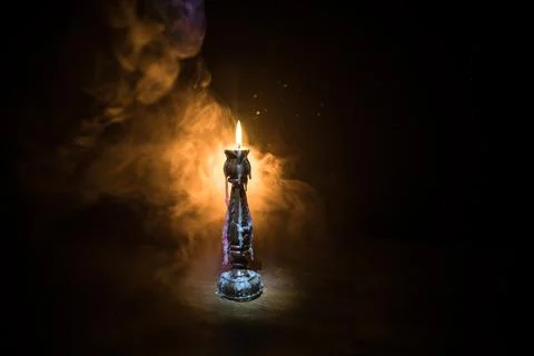 Single burning candle. Light of flame and flowing candle wax, dark background Stock Photos