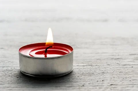 Single burning red tealight candle Stock Photos