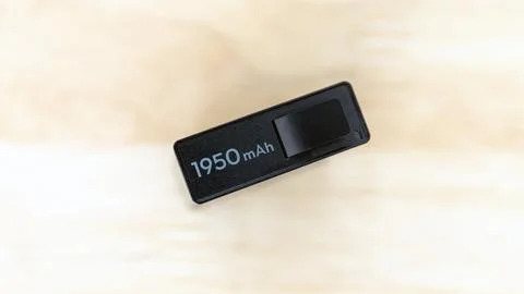Single Camera Battery 1950 mAh Capacity on Wooden Background. Stock Photos
