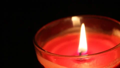 Single candle burning with a black background Stock Footage 135441289