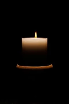 Single candle burning in the dark. Stock Photos