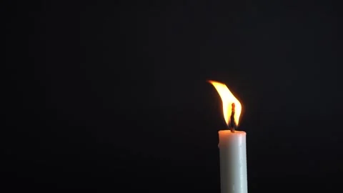 Single candle burns brightly against a dark backdrop Stock Footage 340900690