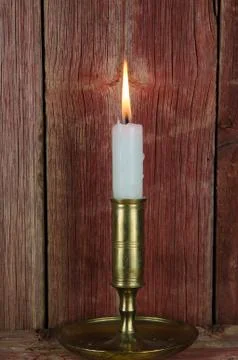 Single candle in candlestick at old wall Stock Photos