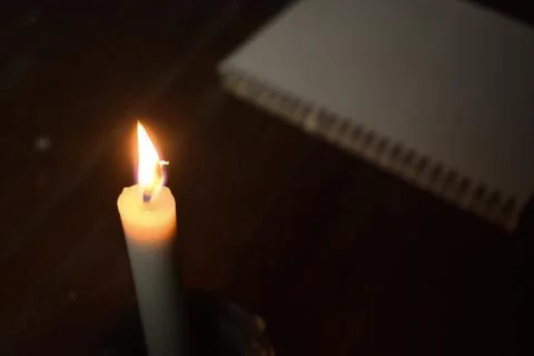 Single Candle with flame in the dark place, isolated black background Stock Photos