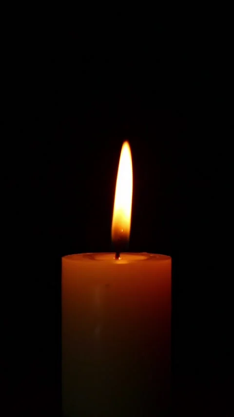Single candle flame flickering and fading in dark studio scene Stock Footage 323529595