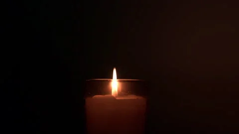 Single Candle Flame Glowing in Glass Jar on Black Background Stock Footage 340911430