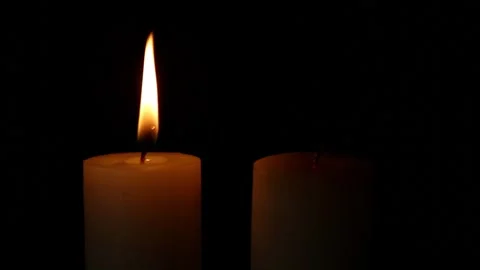 Single candle flame rising in dark minimal scene Stock Footage 323178678