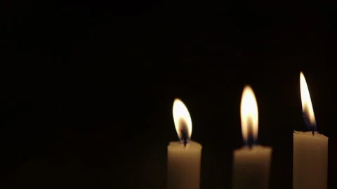 Single candle glowing in darkness on a black background Stock Footage 336468497