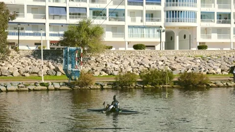 Single canoe polo player practicing shooting the ball toward the goal on the Vidéo 330979056