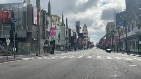 Single car driving down empty Hollywood Blvd during corona virus lockdown Stock Footage 133826406