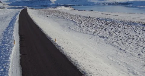 Single car driving down highway in Iceland along snow covered landscape Stockbeeldmateriaal 108468225