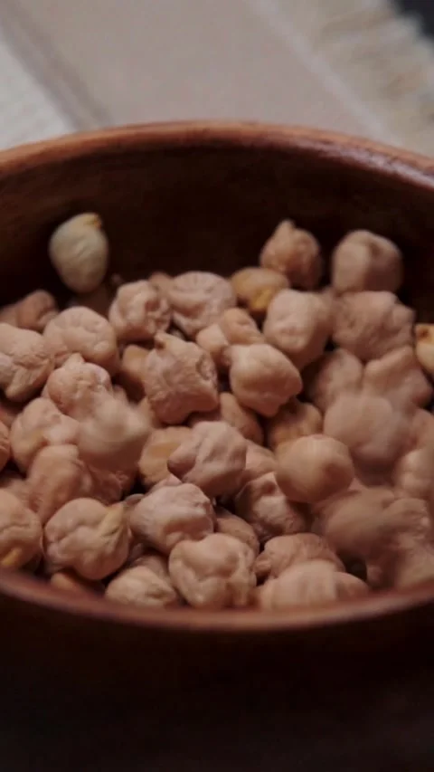 Single Chickpea Dropping into Empty Wooden Bowl Close Up Stock Footage 345205819