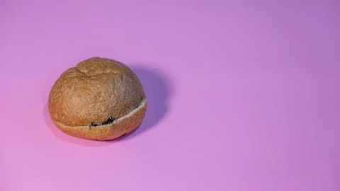 Single Chocolate-Filled Bun on a Solid Pink Background Stock Photos