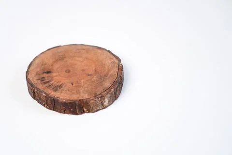 A single circular wooden log slice coaster placed on the left side of a pla.. Stock Photos
