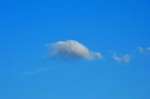 Single cloud on blue summer sky Stock Photos