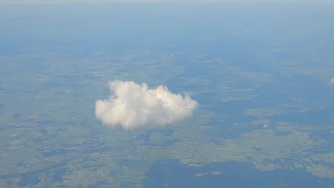 Single cloud floating above a vast green landscape seen from high altitude .. Stock Footage 294895929