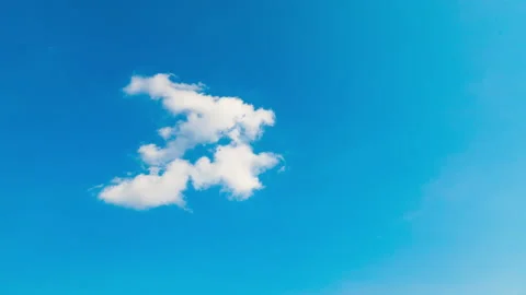 Single cloud moving until dissolving into the blue sky, timelapse Stock Footage
