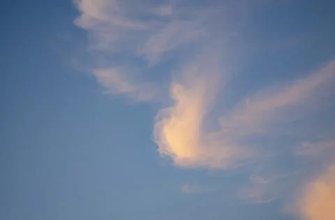 A single cloud of strange shape in the evening sky Stock Photos