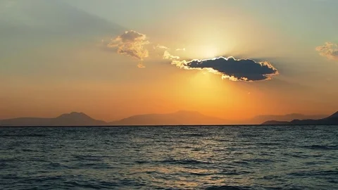 A single cloud veils the morning sun, accompanied by the sea waves sound Stock Footage 315210933