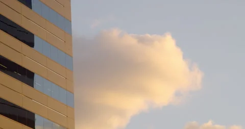 Single clouds in blue sky moving behind tall building Stock Footage 150872051