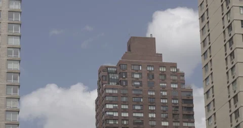 Single clouds in blue sky moving behind tall buildings Stock Footage 150872086