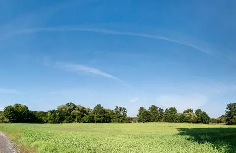 Single clouds in suburban landscape over a rural road Stockfoto's