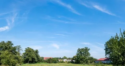 Single clouds in suburban landscape over a rural road 库存照片