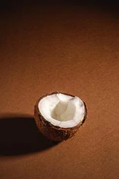 Single coconut fruit on brown plain background, abstract food Stock Photos