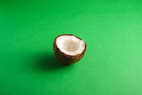 Single coconut fruit on green plain background, abstract food Stock Photos