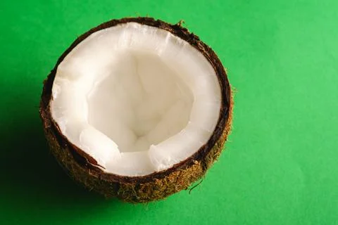 Single coconut fruit on green plain background, abstract food Stock Photos