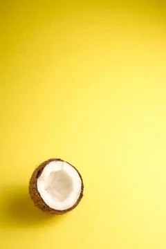 Single coconut fruit on yellow plain background, abstract food tropical Stock Photos
