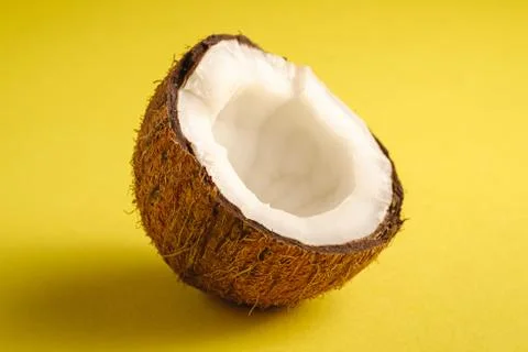 Single coconut fruit on yellow plain background Stock Photos