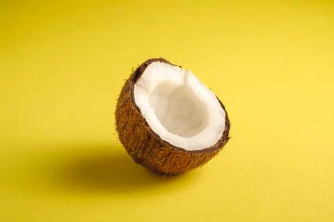 Single coconut fruit on yellow plain background Stock Photos