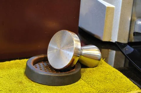 Single coffee-tamper set on yellow cloth. Stock Photos