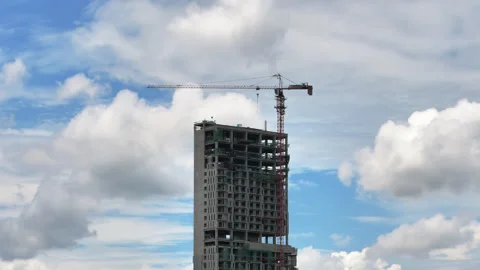 Single concrete building skeleton and tower crane against fast clouds, timelapse 스톡 동영상 346198712